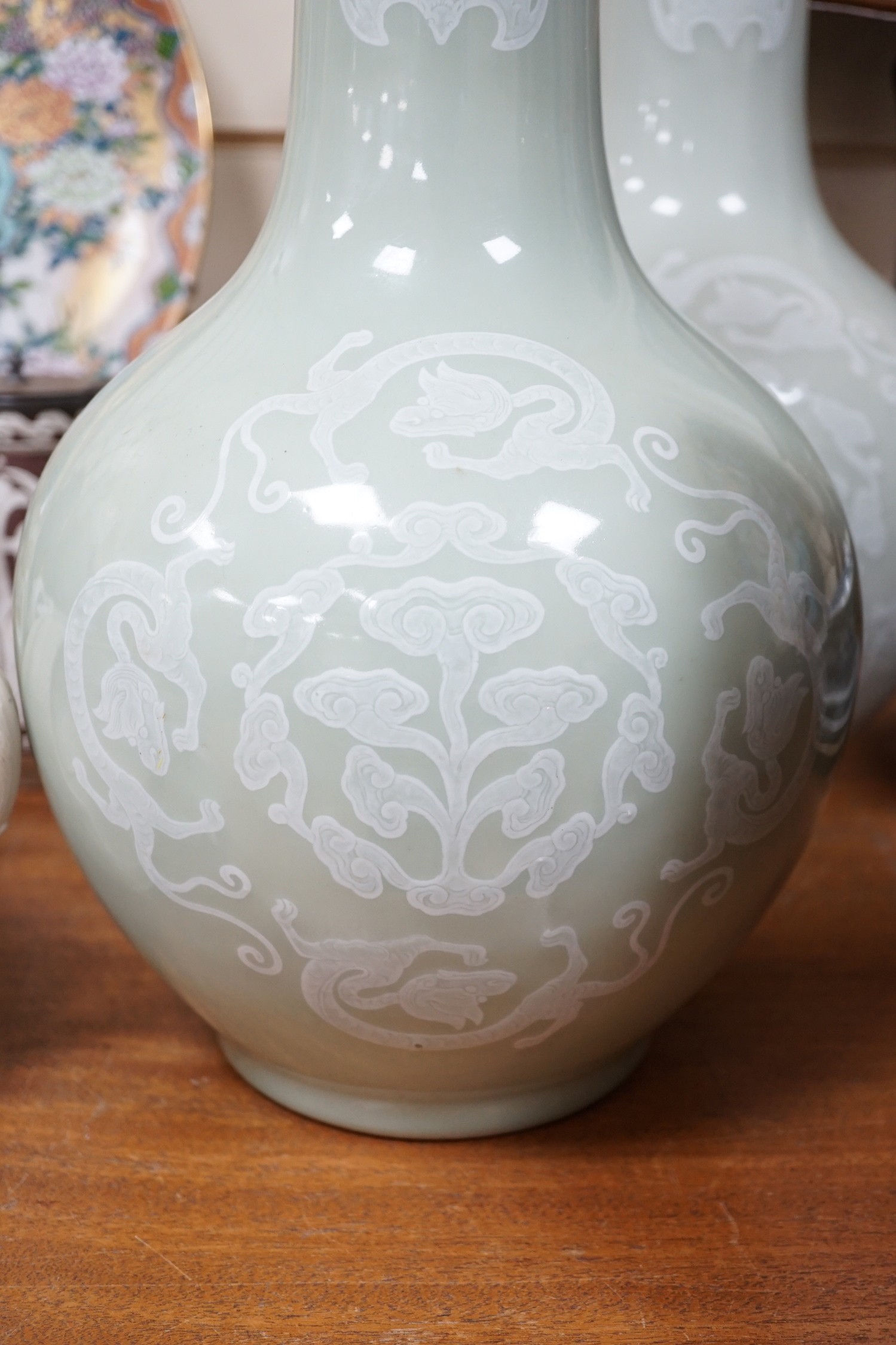 A pair of Chinese white slip decorated celadon glazed bottle vases, mid 20th century, 39cm